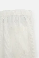 Pantalón relaxed fit de color beige con finas rayas verticales, confeccionado en una mezcla de algodón y cáñamo. Presenta cintura elástica, bolsillos laterales, un bolsillo trasero de plastrón y cierre frontal con botones.