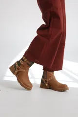 Bota corta de cuero color marrón claro, con detalles de correas con hebillas y apliques metálicos.