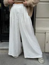 Pantalón sastrero negro de corte palazzo, con botón, pasacinto y pretina trasera con elástico.