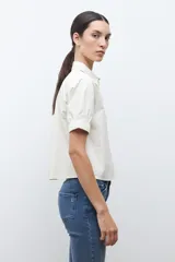 Camisa de vestir color azul marino, con cuello clásico y cierre frontal de botones.