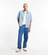 Camisa masculina oversized boxy de manga corta, confeccionada en tejido oxford a rayas verticales celestes y blancas. Cuenta con cuello inglés, abotonadura frontal y bolsillo de parche en el pecho.