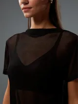 Remera negra de mangas cortas y corte ajustado, confeccionada en tejido de red transparente.