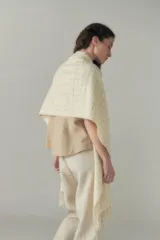 Chal de lana fina sin teñir, con calce en hombros, abrochadura con alamar de fieltro, bolsillos de cuero y terminación con flecos. Diseño exclusivo de Don Baez, hecho en Uruguay.