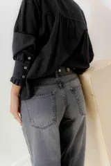 Pantalón jean de tiro medio color negro, corte mom, con bolsillos delanteros y traseros. Largo hasta el tobillo. Confeccionado en algodón 100%.