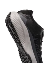 Championes Umbro modelo Adventure para hombre, color negro con detalles en gris oscuro. Presentan una capellada de malla transpirable con refuerzos sintéticos y la marca Umbro en relieve sobre el lateral. La suela es gruesa, de color gris claro, con una base negra.