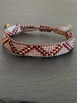 Pulsera tejida con cuentas MIYUKI en tonos dorado, bordó y champagne.
