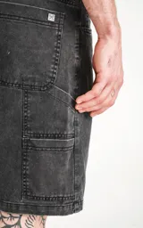 Bermuda de denim negro con diseño cargo, detalles de costura visible y múltiples bolsillos.