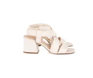 Sandalia de cuero color blanco hueso, con tiras cruzadas acolchadas, talón elástico fruncido, taco ancho de 6 cm y punta cuadrada.
