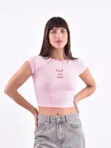 Remera corta color rosa con cuello redondo y mangas cortas. Estampado frontal con la frase "C'est la vie" en color rojo.