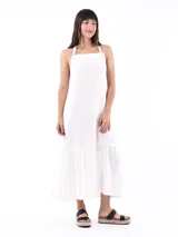 Vestido largo blanco de lino, con breteles finos que se atan en los hombros y falda con volantes.