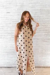 Camisola midi color beige con estampado de lunares negros, cuello camisero, sin mangas y abotonada al frente.