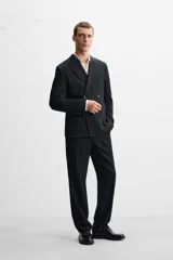 Pantalón de vestir negro slim fit confeccionado en tejido de lana de origen italiano. Cuenta con bolsillos frontales y traseros de vivo con botón. Cierre frontal con cremallera y botón. Colección especial Origins.