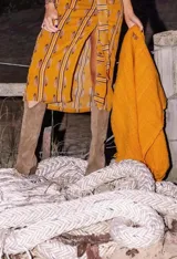 Ruana color maíz confeccionada en lana merino, de tejido suave y ligero con flecos en el borde inferior.