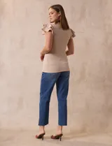 Remera beige de tejido acanalado, con cuello redondo y mangas cortas con volados.