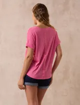 Remera celeste de corte recto, con cuello redondo y mangas cortas con dobladillo. Presenta detalle de botones en la espalda.