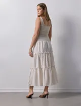 Falda midi a rayas verticales celestes y blancas, con pretina ancha elastizada en punto smock y volados en los cortes.