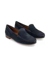 Mocasín azul marino de gamuza, estilo penny loafer, con costuras visibles en contraste color marrón claro y suela de goma marrón.