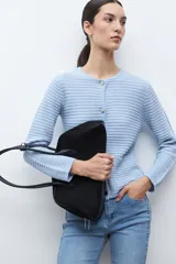 Chaqueta de punto color celeste claro, de manga larga y corte ajustado, con cuello redondo y cierre frontal de botones metálicos plateados. El tejido presenta un patrón texturizado horizontal.