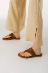 Sandalias marrones de cuero con apliques de tachas doradas.