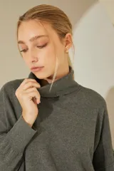 Sweater negro oversize de tejido de punto, con cuello alto y detalle de costuras a la vista.