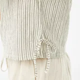Top sin mangas color beige con rayas verticales en verde claro, cuello redondo y lazos laterales ajustables.
