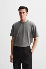 Camiseta gris de algodón, corte recto, cuello redondo y manga corta.