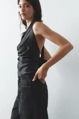 Top negro de satén con cuello halter drapeado ajustable con lazada en el cuello y espalda descubierta con lazada.