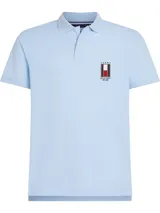Chomba celeste de piqué de algodón con cuello clásico, tapeta de dos botones y logo vertical bordado en el pecho.