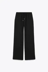 Pantalón negro de tiro alto con cintura elástica ajustable con cordones, bolsillos delanteros y pernera ancha.