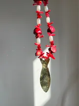Collar con cuentas de coral rojo, perlas blancas y dije de bronce con forma de pez.