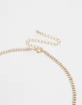 Gargantilla dorada con cadena de strass y dije de corazón con strass.