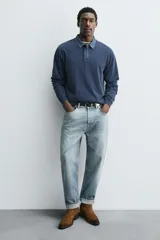 Bota estilo cowboy de cuero color marrón con acabado serraje engrasado, caña media con pespuntes decorativos, tiradores laterales, tacón ancho y punta cuadrada.