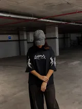 Remera de algodón negra con cuello alto y corte boxy/oversize. Estampa frontal y en mangas con diseño tribal en color blanco.