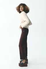 Jeans de tiro alto color marrón, corte slim fit y bootcut, con cinco bolsillos y cierre frontal con cremallera y botón.