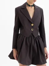 Saco blazer cropped color marrón con rayas finas, confeccionado en lanita. Presenta solapa en pico profunda, hombreras y cierre frontal con dos botones dorados.