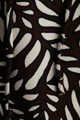 Short marrón con estampado de hojas blancas, cintura elástica con cordón ajustable y bolsillos laterales.