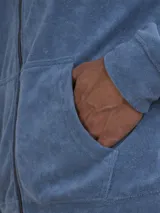 Campera con capucha de toalla de algodón color verde azulado, con cierre frontal y bolsillos laterales.