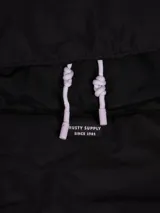 Mochila negra de diseño minimalista con un bolsillo frontal y cierre principal.