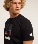 Remera negra de algodón con cuello redondo y manga corta. Estampado frontal con el logo de Kodak a la altura del pecho.