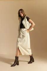 Falda larga de mezclilla color crema, de corte recto y talle alto, con costuras visibles en contraste y abertura frontal.