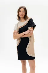 Vestido corto de algodón, con bloques de color en tonos pastel (amarillo claro, beige y rosado pálido) unidos por volados fruncidos en tonos marrón claro y amarillo. Presenta cuello redondo y mangas cortas.