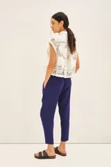 Pantalón babucha color mostaza, con elástico en la cintura y cordón ajustable con terminaciones metálicas. Tiene bolsillos diagonales en el frente y falsos bolsillos ojal en la espalda.