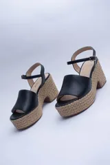 Sandalias negras de cuero con plataforma de yute y pulsera al tobillo.