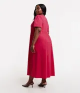 Vestido midi de media malla color fucsia, con cuello redondo, manga corta abullonada y corte en V en la cintura.