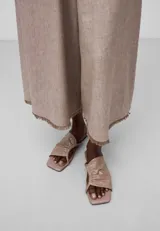 Pantalón cropped color beige de lino europeo y viscosa responsable, con trabillas, bolsillos laterales y traseros, pierna ancha y bajo desflecado.