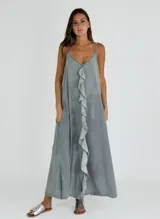Vestido largo color gris con breteles finos y volados verticales en el frente.