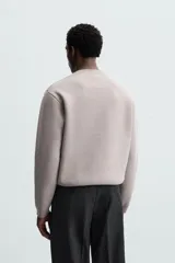Sweater negro de punto con cuello redondo y mangas largas.