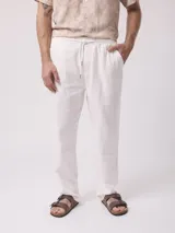 Pantalón de vestir blanco, de corte recto, con cintura elástica tipo jogger y bolsillos laterales.