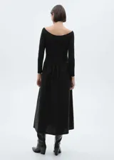 Vestido largo negro de tejido de punto con cuello redondo, corte evasé y detalles fruncidos.