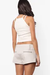 Short negro de cuerina, tiro bajo con doble cintura y cierre frontal con cremallera metálica YKK.